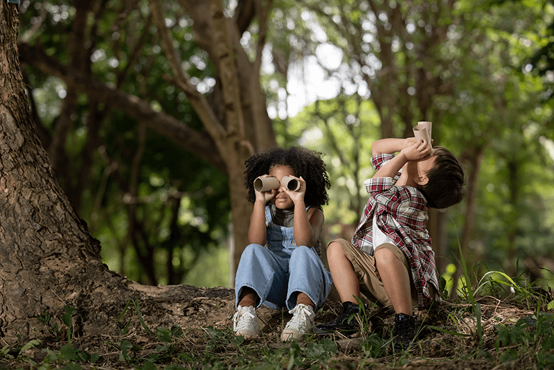 Kids using binoculars in nature